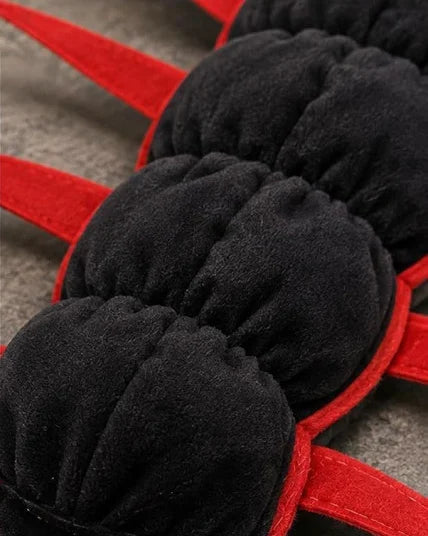 Close-up of the padded black plush sections and red legs of the Centipede Cat Costume
